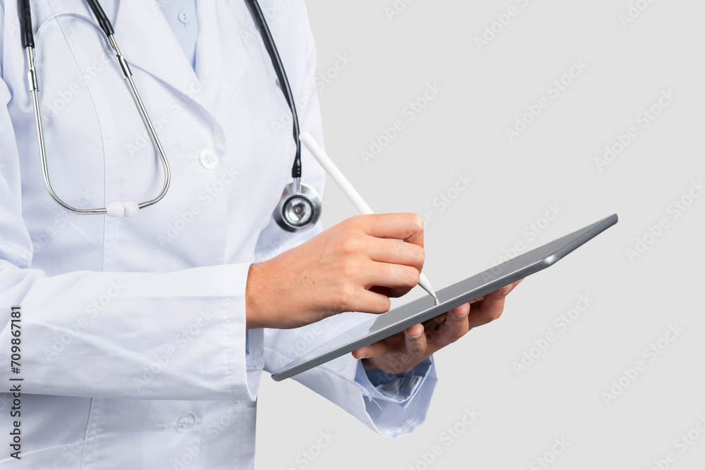 A professional female healthcare provider in a white lab coat uses a digital tablet with a stylus A professional female healthcare provider in a white lab coat uses a digital tablet with a stylus