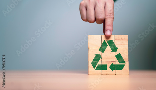 Photos Hand holding green recycle label on wooden block cube for ecological to save earth and sustainable development to success in business growth concept