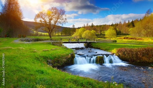 beautiful meadow with a river  a waterfall  a small bridge