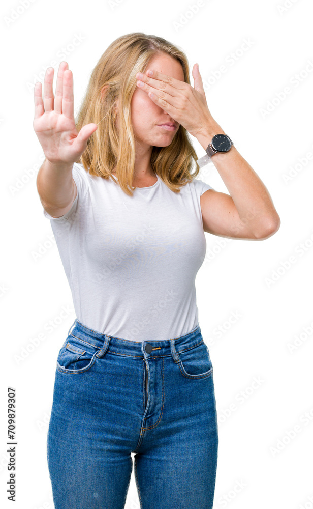 Beautiful young woman wearing casual white t-shirt over isolated background covering eyes with hands and doing stop gesture with sad and fear expression. Embarrassed and negative concept. Beautiful young woman wearing casual white t-shirt over isolated background covering eyes with hands and doing stop gesture with sad and fear expression. Embarrassed and negative concept.