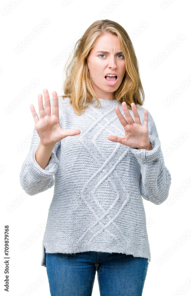 Beautiful young woman wearing winter sweater over isolated background afraid and terrified with fear expression stop gesture with hands, shouting in shock. Panic concept. Beautiful young woman wearing winter sweater over isolated background afraid and terrified with fear expression stop gesture with hands, shouting in shock. Panic concept.