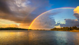 Beautiful cloudscape over the lake during sunset with a rainbow