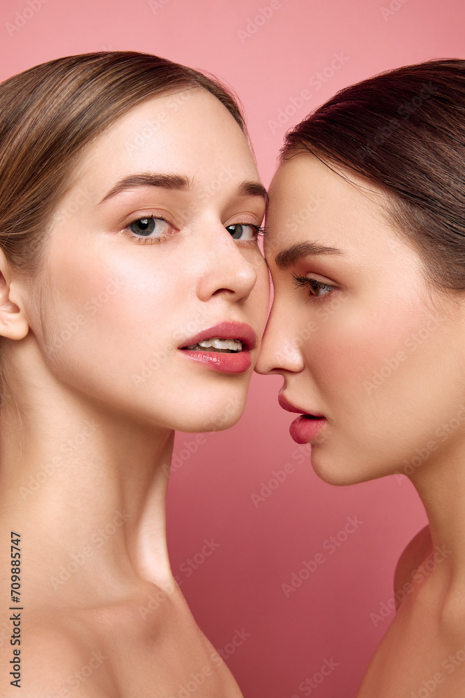 Bare-faced brilliance. Girls radiate beauty in unity. Close up of two pretty ladies with bare shoulders posing against pink studio background. Concept of health, self care, cosmetic products, make-up. Bare-faced brilliance. Girls radiate beauty in unity. Close up of two pretty ladies with bare shoulders posing against pink studio background. Concept of health, self care, cosmetic products, make-up.