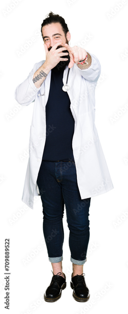 Doctor with long hair wearing medical coat and stethoscope Laughing of you, pointing to the camera with finger hand over mouth, shame expression Doctor with long hair wearing medical coat and stethoscope Laughing of you, pointing to the camera with finger hand over mouth, shame expression