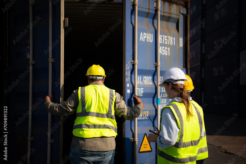 Group of workers in an empty container storage yard, The condition of the old container is being assessed to determine whether it requires maintenance for usage. Group of workers in an empty container storage yard, The condition of the old container is being assessed to determine whether it requires maintenance for usage.