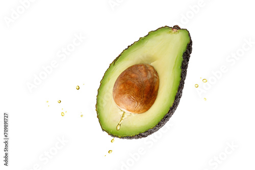 Cutting green avocado with oil drops flying isolated on white photo