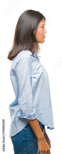 Young asian business woman over isolated background looking to side, relax profile pose with natural face with confident smile.