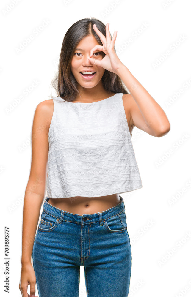 Young asian woman over isolated background doing ok gesture with hand smiling, eye looking through fingers with happy face. Young asian woman over isolated background doing ok gesture with hand smiling, eye looking through fingers with happy face.