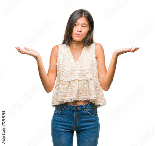 Young asian woman over isolated background clueless and confused expression with arms and hands raised. Doubt concept.