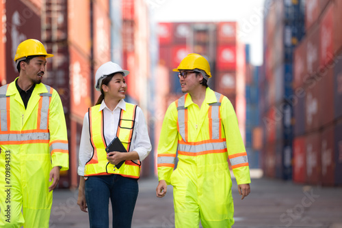 Group of engineers working with laptop in the container yard. This is a freight transportation and distribution warehouse.