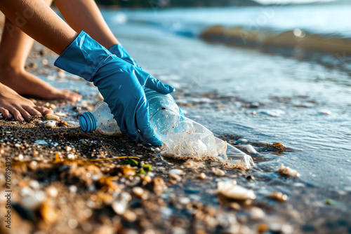 Detalle de manos recogiendo basura de una playa para prevenir la contaminación por plásticos micro plásticos © Julio