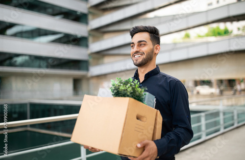 young professional arabic businessman carries belongings box reflecting optimism outdoor