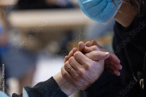 une personne avec un masque de protection tient les mains d'une personne âgée. Symbole de solidarité intergénérationnelle photo