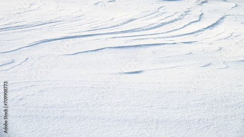 Fresh snow texture in blue tone as background.