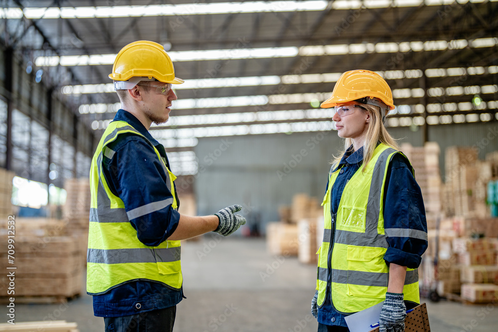 workers man and woman engineering walking and handshakeing with working suite dress at warehouse. Concept of smart industry worker operating. Wood factories produce wood palate workers man and woman engineering walking and handshakeing with working suite dress at warehouse. Concept of smart industry worker operating. Wood factories produce wood palate