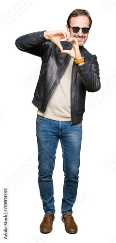 Middle age handsome man wearing sunglasses and black leather jacket smiling in love showing heart symbol and shape with hands. Romantic concept. © Krakenimages.com