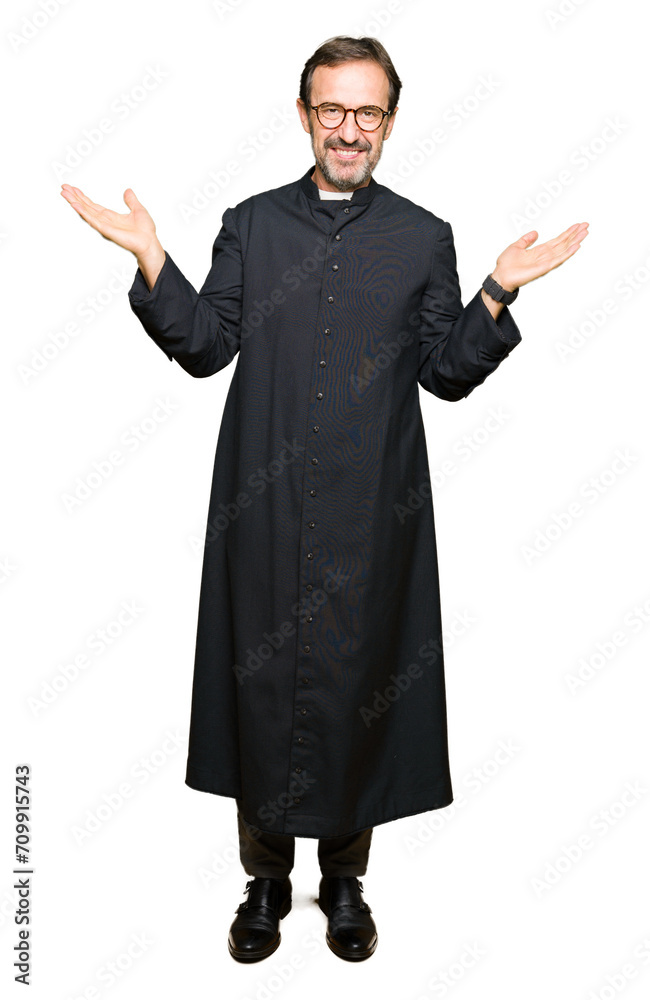 Middle age priest man wearing catholic robe Smiling showing both hands open palms, presenting and advertising comparison and balance Middle age priest man wearing catholic robe Smiling showing both hands open palms, presenting and advertising comparison and balance