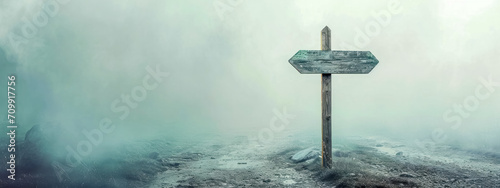 wooden signpost on a foggy road, choose a direction, decide