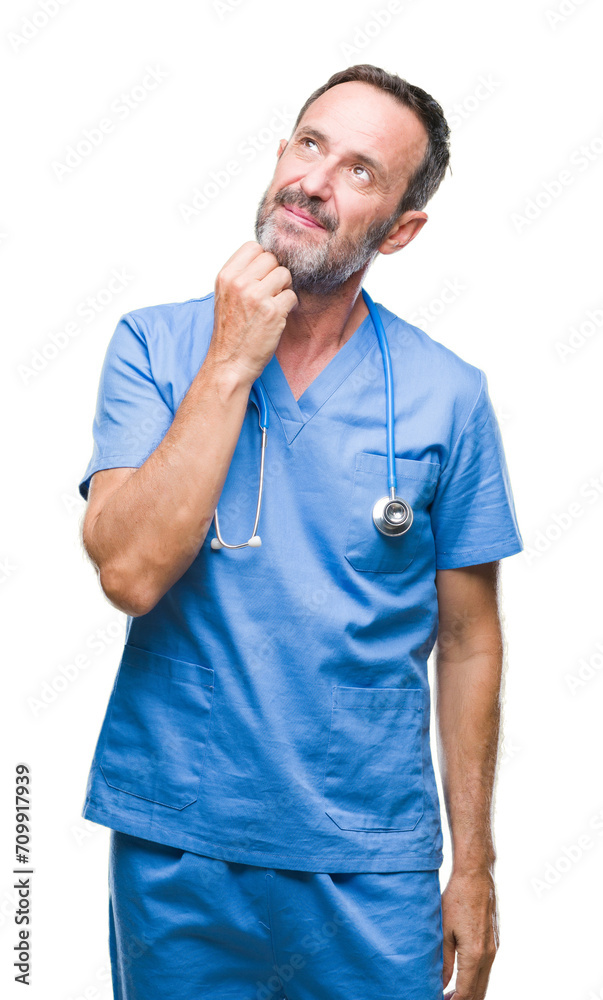 Middle age hoary senior doctor man wearing medical uniform over isolated background with hand on chin thinking about question, pensive expression. Smiling with thoughtful face. Doubt concept. Middle age hoary senior doctor man wearing medical uniform over isolated background with hand on chin thinking about question, pensive expression. Smiling with thoughtful face. Doubt concept.