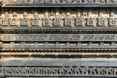 Beautiful intricate patterns and carvings of figurines on the wall of the ancient Chennakeshava temple in Belur, Karnataka.