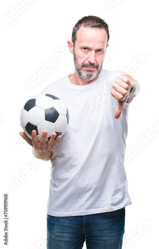 Middle age hoary senior man holding soccer football ball over isolated background with angry face, negative sign showing dislike with thumbs down, rejection concept