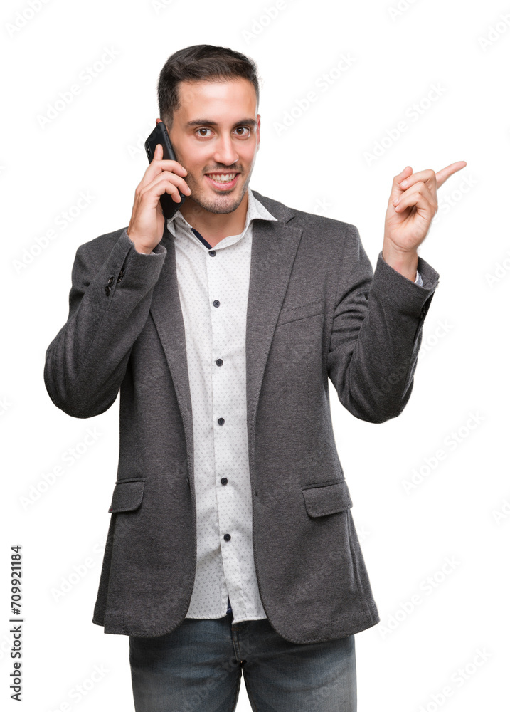 Handsome young man using smartphone very happy pointing with hand and finger to the side Handsome young man using smartphone very happy pointing with hand and finger to the side