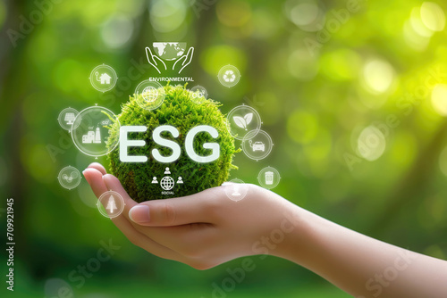 Hand holding global ESG icon of saving clean energy environmental, social, governance, sustainable and corporation development, green eco friendly, environment, go green, CO2, ESG concept on green