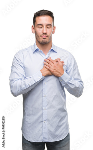 Handsome young businessman smiling with hands on chest with closed eyes and grateful gesture on face. Health concept.