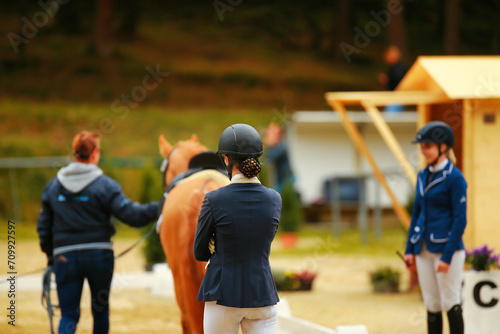 Horse dressage, dressage horse being presented for the aptitude test, rider from behind looking at her horse.