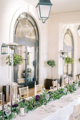 Set festive table with flowers and candles near gas heaters © Nadtochiy