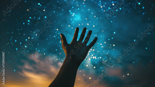 hand reaching out to starry night sky