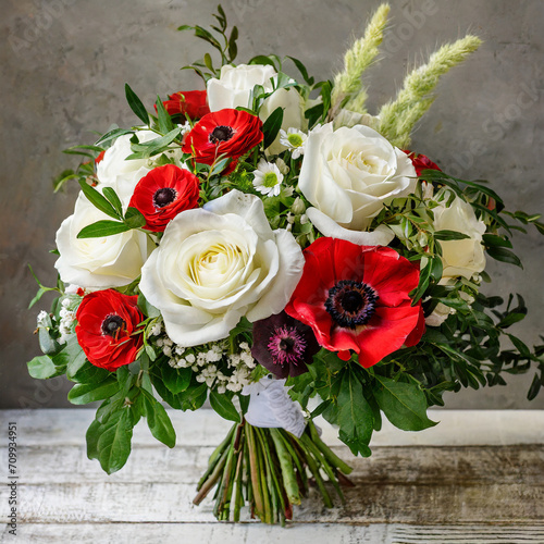 bouquet of flowers with white roses  red anemones  and greenery