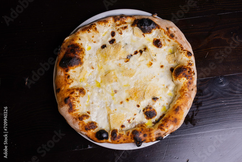 Pizza tradizionale napoletana ai quattro formaggi servita in una pizzeria