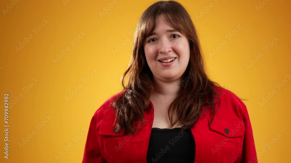 Portrait of pretty thinking young woman 20s, looks at camera gives mind blown gesture showing explosion of ideas posing on yellow background with copy space.