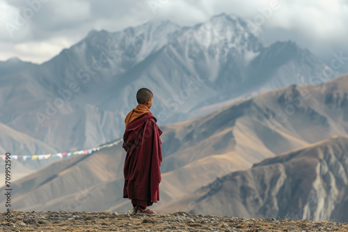 A 12 - year - old Tibetan monk, adorned in traditional maroon and saffron robes, standing against the backdrop of the Himalayan mountains.