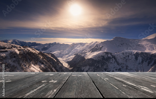 Beautiful winter sunset over mountains with empty wooden table. Natural template landscape