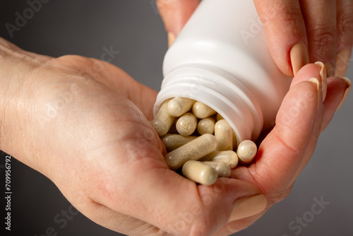 Female hands holding a heap of capsules, collagen, vitamins, pain killers, food supplements pills.