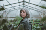 mature woman as a gardener working in a greenhouse 