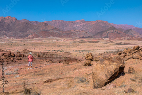 A tourist ponders the solitude of the rocky Damaraland area on the edge of the Namib desert in the Erongo district of northwestern Namibia.