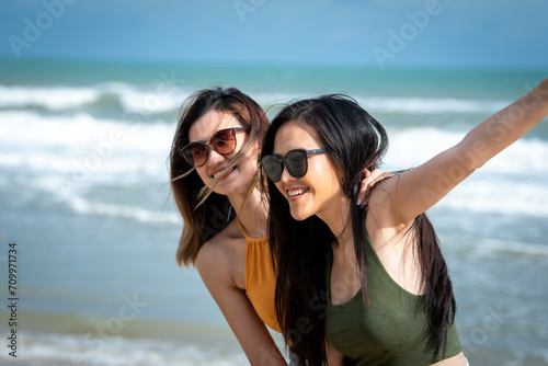 Portrait of two Happy traveller woman wearing straw enjoys her during summer tropical beach vacation