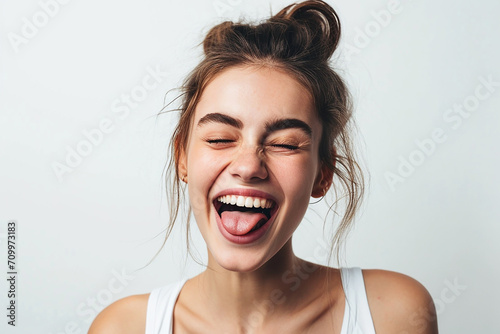 closeup shot of attractive young woman winking joyfully and showing tongue sassy on white isolated background