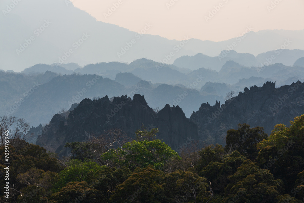 Silhouettes of limestone rocky hills at sunset. Laos