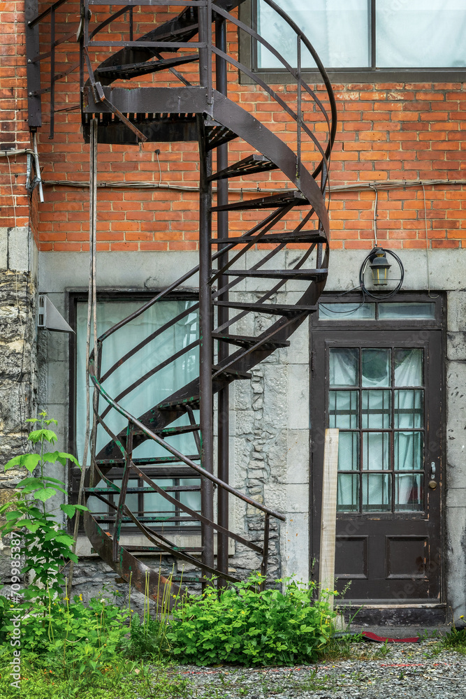 Rusty metallic outside spiral stairs on a brick building in Montreal, Canada