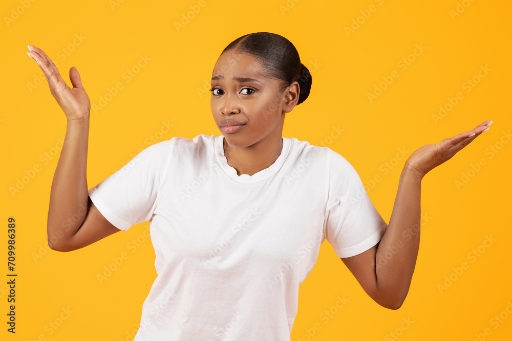 Unsure Puzzled Black Woman Shrugging Shoulders Against Yellow Studio Backdrop Unsure Puzzled Black Woman Shrugging Shoulders Against Yellow Studio Backdrop