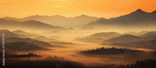 Enchanting silhouette of hills in misty sunset.