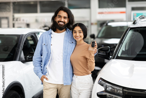 Fotografia Cheerful indian couple bought nice auto, car store interior
