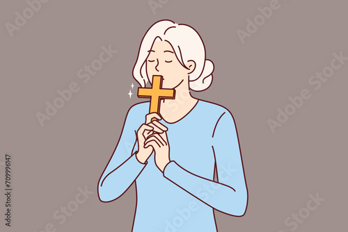 Catholic woman kisses christian cross, making ritual worshiping religious shrine and expressing respect to lord. Catholic girl with crucifix in hands thanks god for remission sins or makes confession