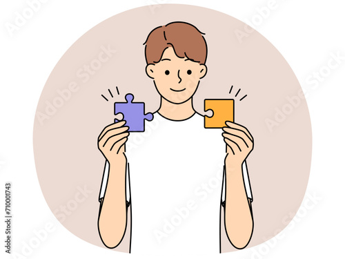 Smiling man connect jigsaw puzzles