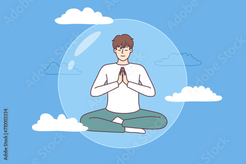 Meditating man does yoga in lotus position in transparent bubble flying in sky and performing zen exercises. Guy is protected by imaginary cocoon that appeared thanks to meditation and yoga