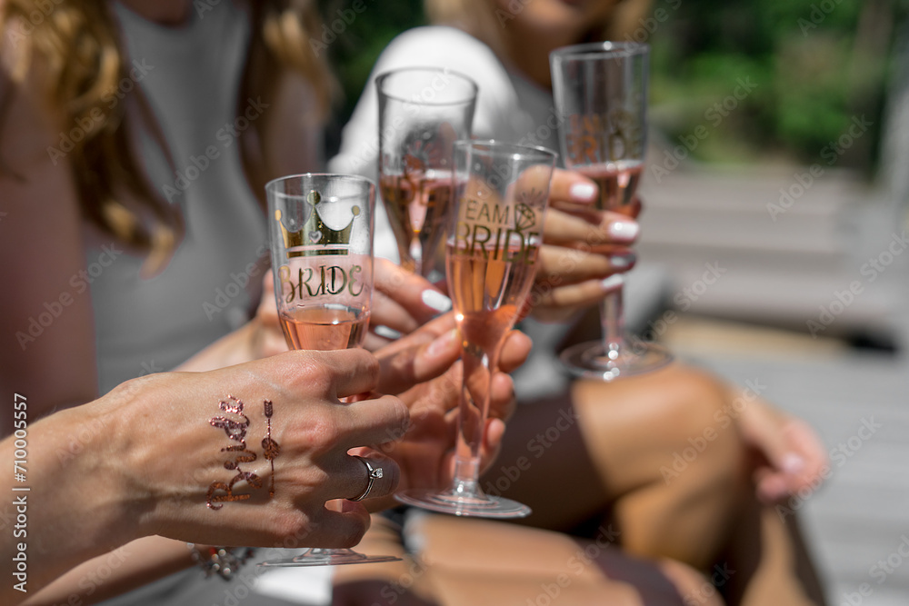 girls sit and hold glasses of champagne in  the hands with stickers at the party